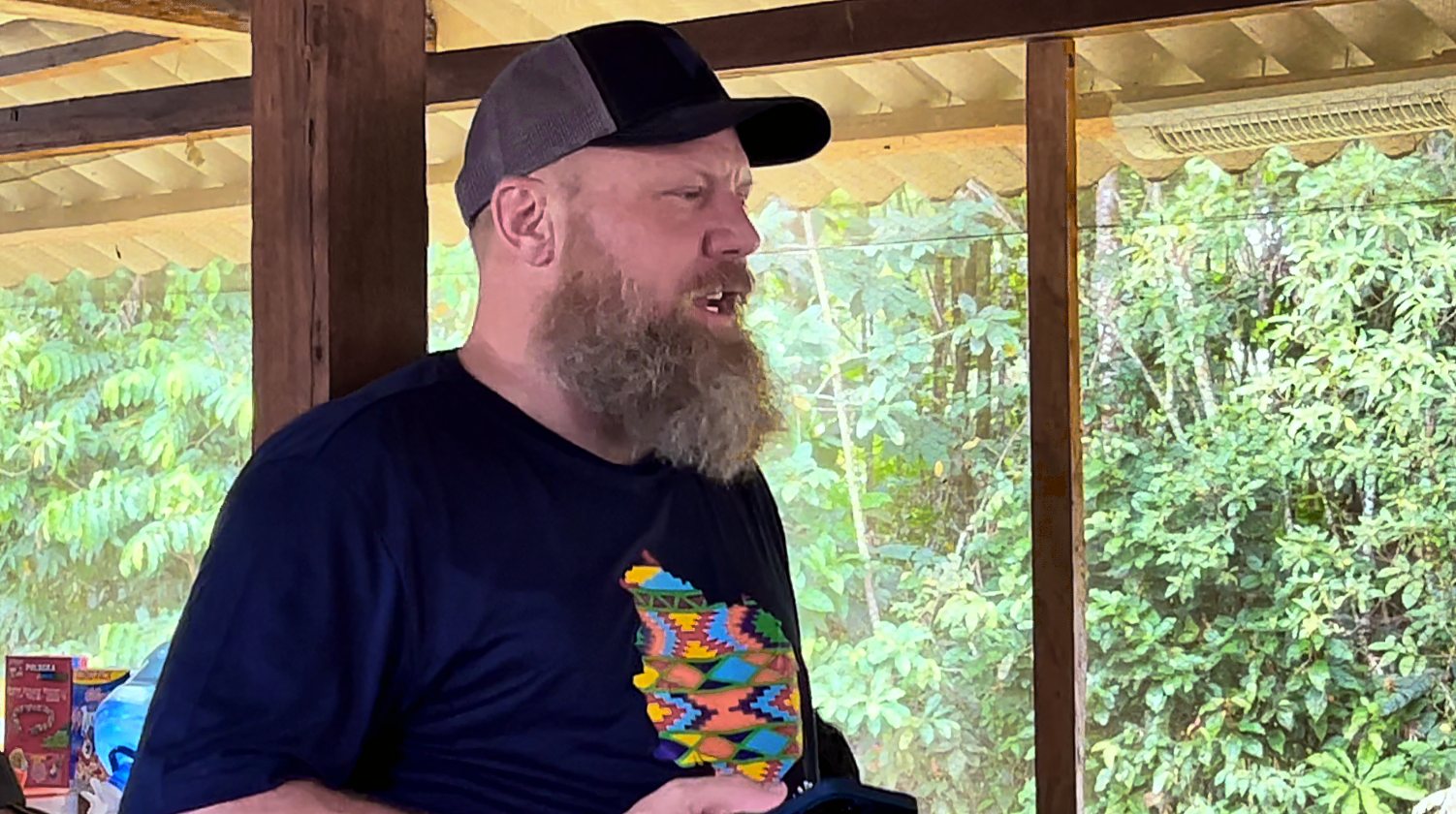 Chad Booth talking with the group under the shelter