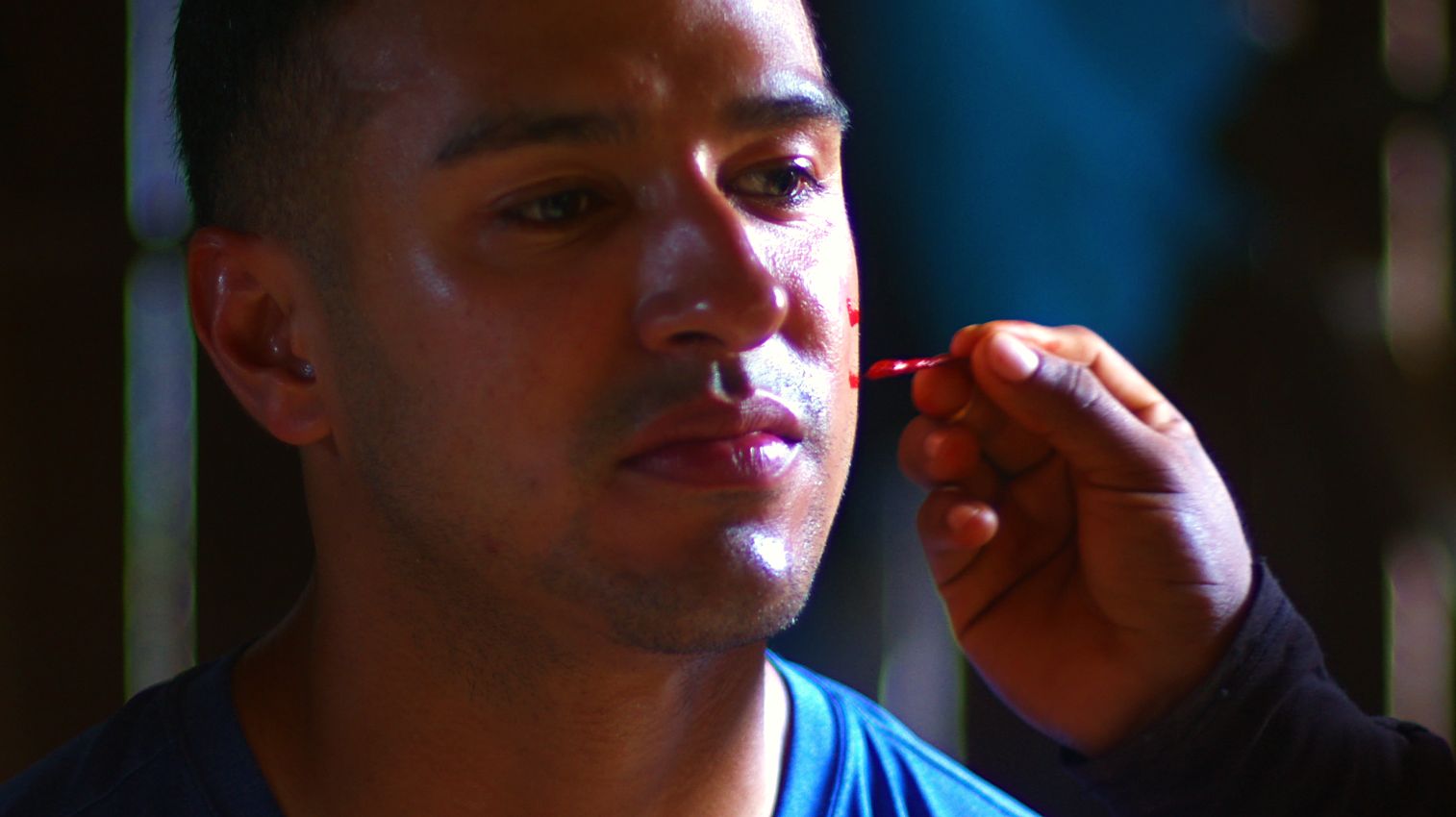A volunteer having his face painted in the village