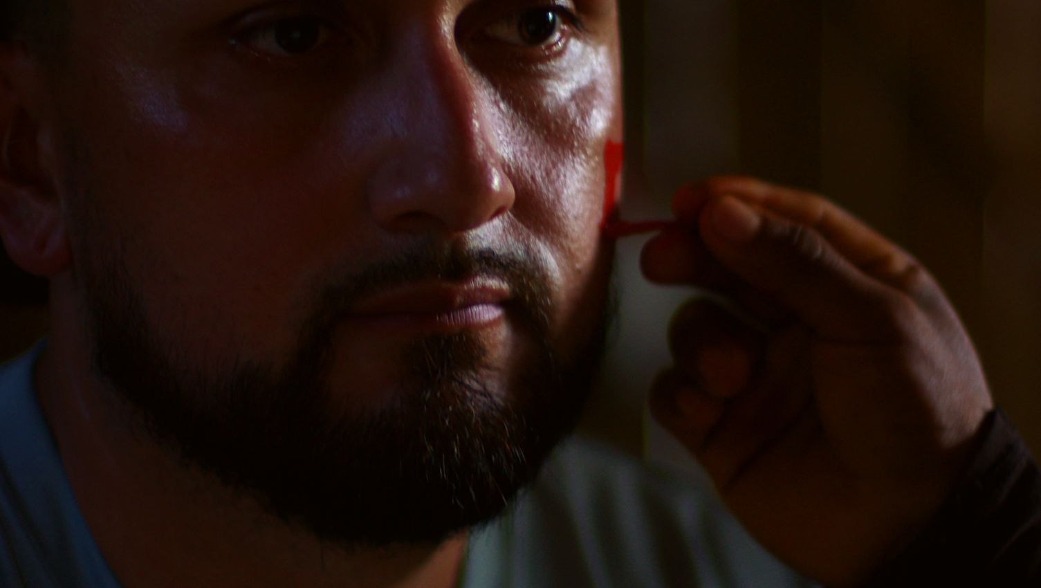 A villager painting a volunteer’s cheek