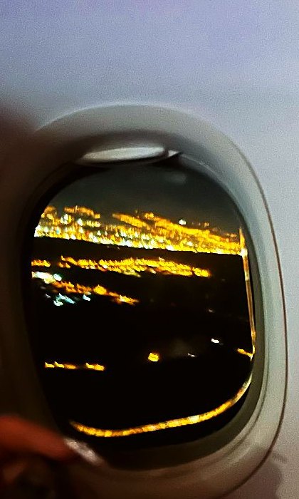 City lights through the airplane window at night